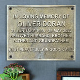 A brass memorial plaque with an inscription honoring the memory of Oliver Dorean, dated January 31, 1933, with a resting place designation.